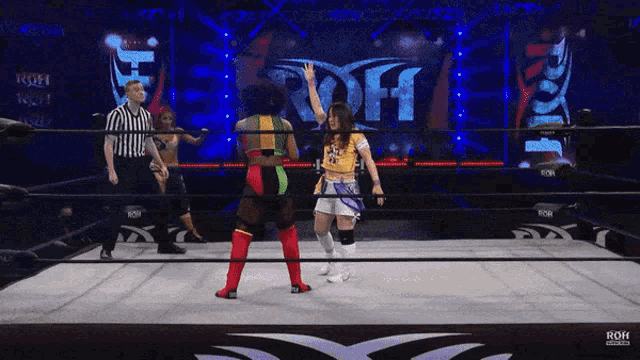 two women in a wrestling ring with the word roh on the wall