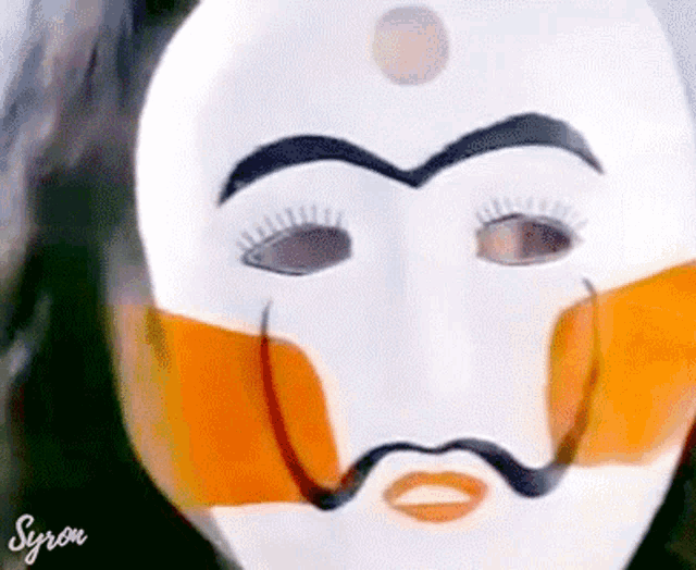 a white mask with a mustache and a circle on the forehead has syron written on the bottom