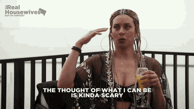 a woman with braids is holding a glass of orange juice and says the thought of what i can be is kinda scary