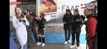 a group of people are standing in front of a parachute paris sign
