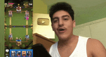 a man in a white tank top is playing a video game