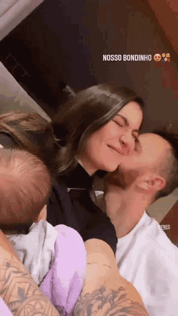 a man is kissing a woman on the cheek while holding a baby with the words nosso bondinho above them