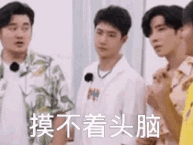 a group of young men are standing next to each other and one of them is wearing a white shirt .