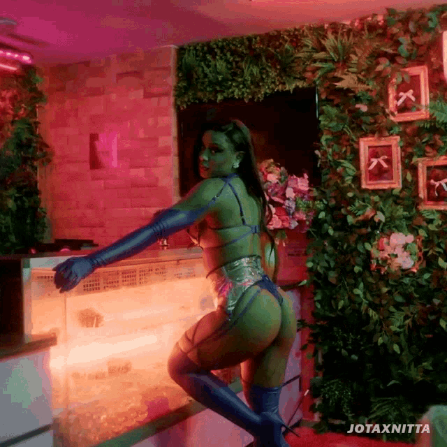 a woman in lingerie is standing in front of a wall that says jotaxnitta on it
