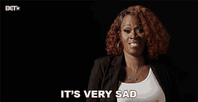 a woman says it 's very sad in front of a black background