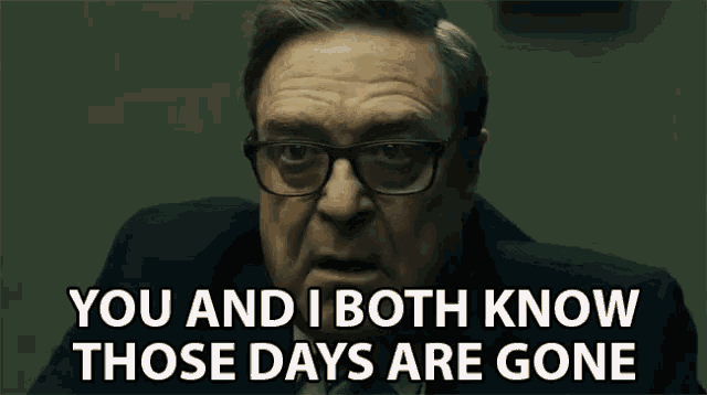 a man wearing glasses and a suit is talking to someone and saying `` you and i both know those days are gone ''
