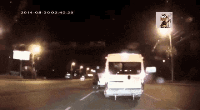 a white van is driving down a street at night with the date 2014 on the bottom right