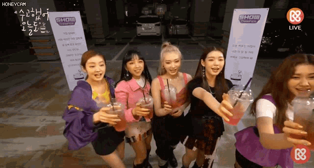 a group of girls holding drinks in front of a sign that says show challenge