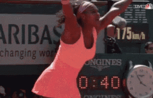 a woman is playing tennis in front of a sign that says ' aribas changing work '