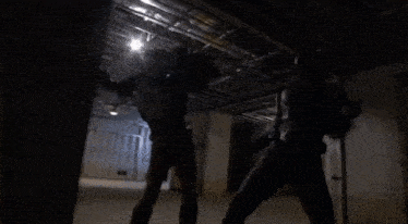 a man in a superhero costume is fighting another man in a room .