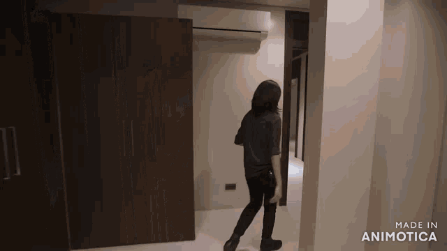 a woman is walking through a hallway with the words made in animotica on the bottom