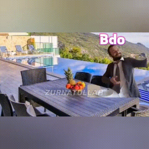 a man is taking a selfie in front of a table with a bowl of fruit on it