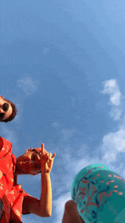 a group of people are standing in front of a blue sky and giving the middle finger