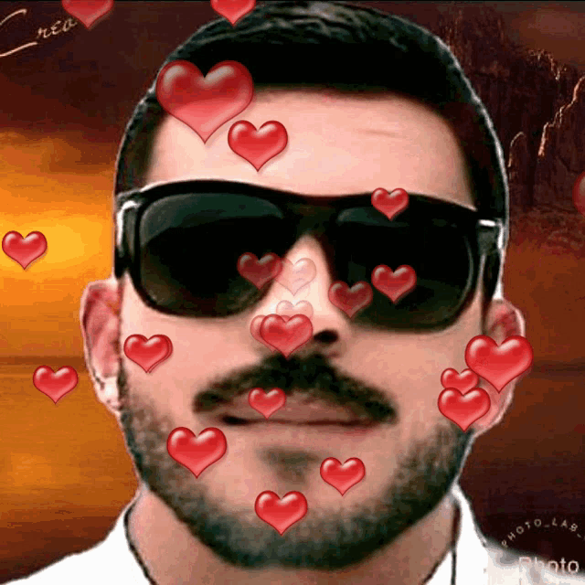 a man with a beard wearing sunglasses has hearts coming out of his face
