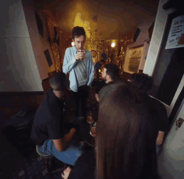 a group of people are gathered in a room with a sign on the wall that says ' open '