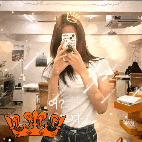 a woman is taking a picture of herself in a mirror with a crown on her hair