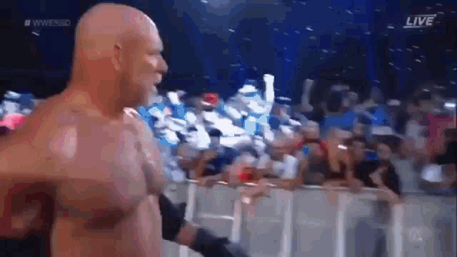 a bald man is standing in front of a crowd .