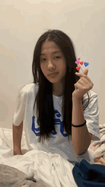 a girl wearing a white shirt with a blue letter u on it