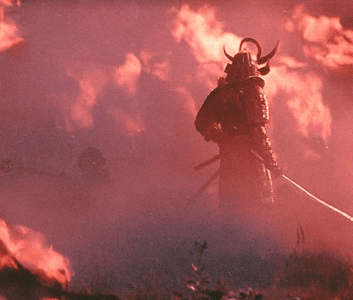 a samurai stands in front of a fire with a sword in his hand