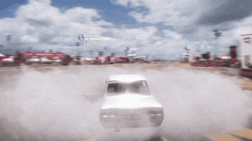 a white car driving down a road with a sign that says 5