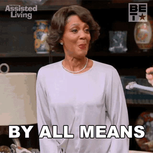 a woman says by all means in front of a lamp