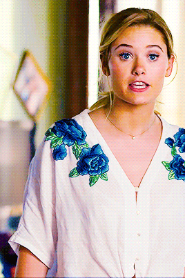 a woman is wearing a white shirt with blue flowers on the sleeves
