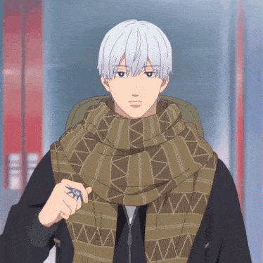 a man with white hair wearing a scarf and a ring on his finger