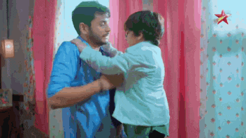 a man and a child are standing next to each other .