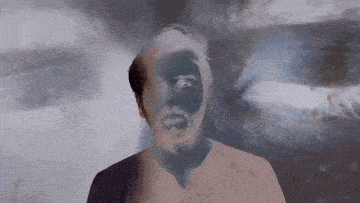 a close up of a man 's face with a black spot on it