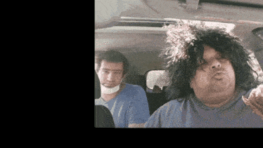 a man with a bandage on his neck is sitting next to a man with long hair