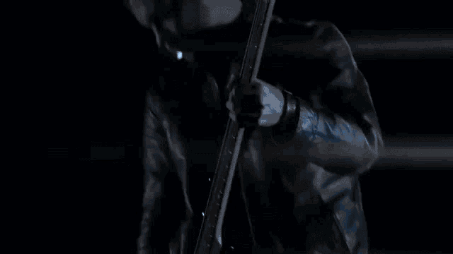 a man in a dark room with a blue light shining on his head