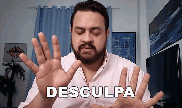a man with a beard is making a gesture with his hands in front of the word desculpa
