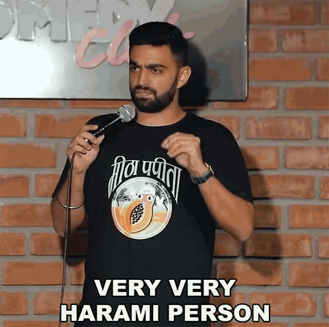 a man in a very very harami person t-shirt is holding a microphone