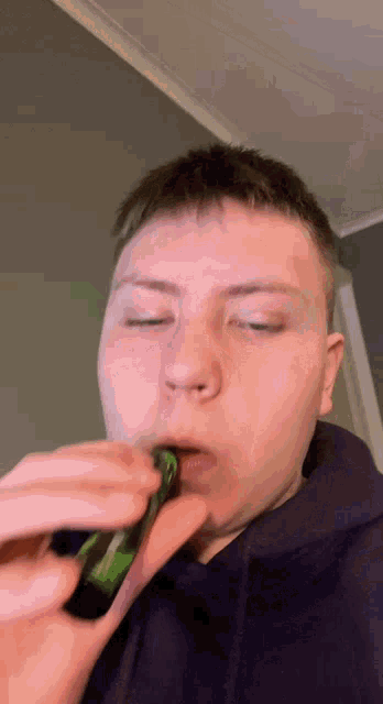 a young man in a purple hoodie is smoking a cigarette