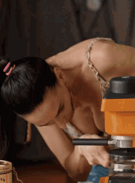 a woman in a leopard print top is working on a machine that has the letter r on it