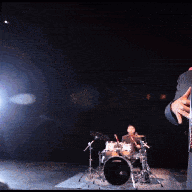 a man playing drums in a dark room