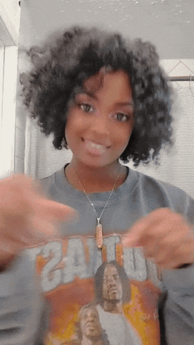 a woman with curly hair wearing a sweater that says 24 on it