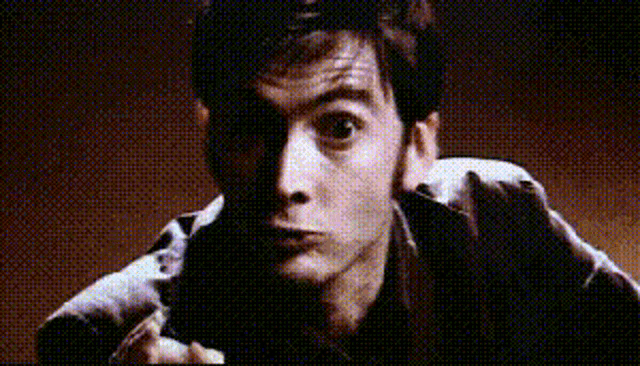 a man is pointing at the camera with a gun