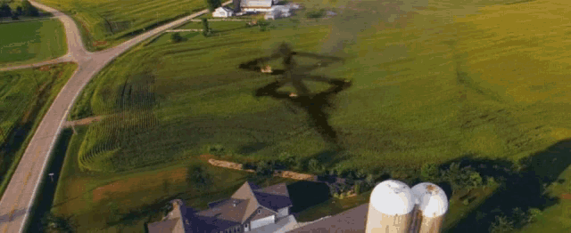 an aerial view of a farm with smoke coming out of a grassy field