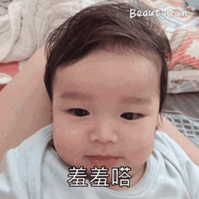 a baby with chinese writing on his face is being photographed with beauty cam