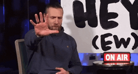 a man sitting in front of a sign that says hey ( ew )