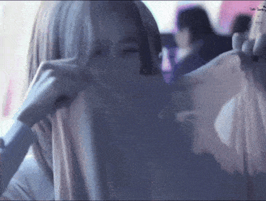 a woman is covering her face with a piece of fabric .