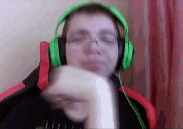 a man wearing green headphones is holding a banana in his hand .