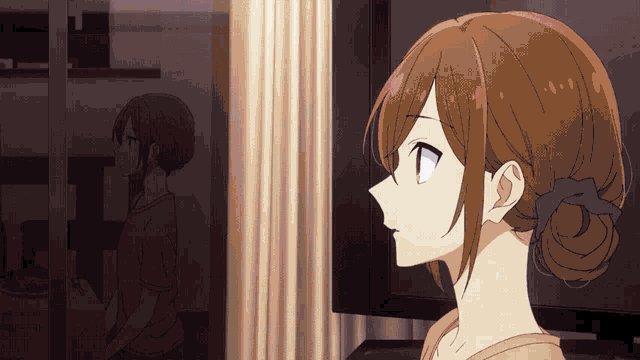 a girl with brown hair is looking out a window at her reflection