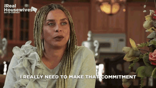 a woman says " i really need to make that commitment " in front of flowers