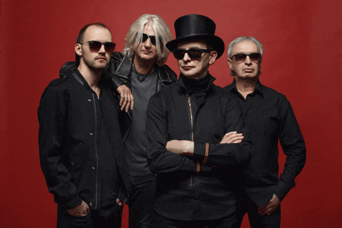 a group of men wearing sunglasses and top hats pose for a picture