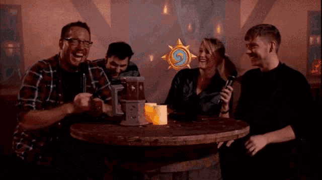 a group of people are sitting around a table with a woman holding a microphone in front of them