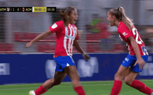 two female soccer players are celebrating a goal during a match