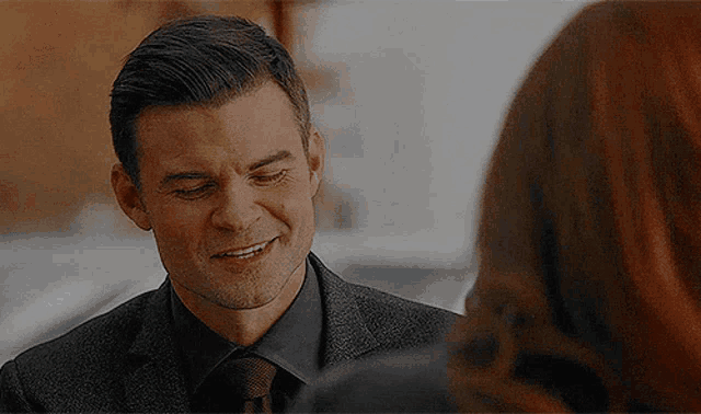 a man in a suit and tie is talking to a woman .