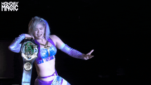 a woman in a purple top and blue gloves holds a wrestling belt in front of monday magic